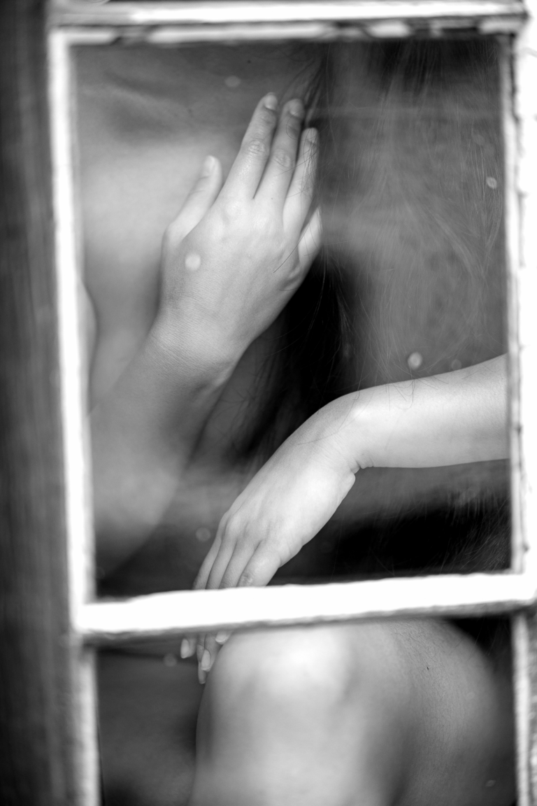 Hands and torso behind glass